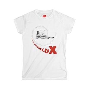 May include: White t-shirt with a red heart-shaped tag at the neckline. The shirt features a black and white graphic of a reclining figure surrounded by musical notes and the word "LUX" in red.