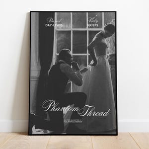 Può includere: Poster cinematografico incorniciato in bianco e nero per "Phantom Thread" con Daniel Day-Lewis e Vicky Krieps. Il poster mostra un uomo in ginocchio e una donna in piedi, con il titolo in elegante scrittura.