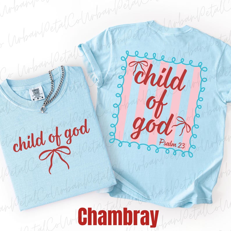 May include: Two light blue t-shirts with the text "child of god" in red script. One shirt has a bow graphic, the other has a pink and blue striped design with the same text and "Psalm 23". A silver chain necklace is on one shirt. The word "Chambray" is at the bottom.