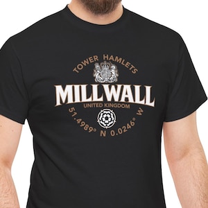 Puede incluir: Camiseta negra con la inscripción blanca "MILLWALL", "TOWER HAMLETS" arriba y "UNITED KINGDOM" abajo. Incluye un escudo y coordenadas. Una camiseta clásica.