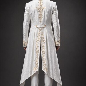 May include: A white tailcoat jacket featuring intricate gold embroidery along the back panel and cuffs, paired with matching white trousers and white shoes. The jacket includes a decorative gold chain detail across the waist and a high collar.