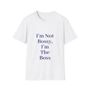 May include: White t-shirt with the text "I'm Not Bossy, I'm The Boss" in navy blue. The shirt has a crew neck and short sleeves. The text is vertically aligned in the center of the shirt.