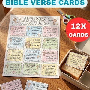 Op de afbeelding: Een vel met twaalf bijbelvers-geheugenkaartjes met pastelkleurige randen, voorzien van diverse schriftverwijzingen en illustraties van kruisen, hartjes en een schaap. Eén kaartje ligt in een lunchtrommel bovenop een boterham.