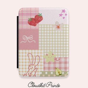 May include: A rectangular object with a patchwork design in pink and beige, featuring strawberries, a bow, a bunny, a star, and a pear. It has a black spine. The text "Cloudkit Prints" is at the bottom.