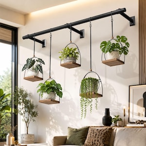 May include: A black metal wall-mounted rod featuring five hanging plant holders. Each holder consists of a circular metal frame with a small wooden base supporting a potted plant. The plants include various green foliage, such as a trailing succulent.