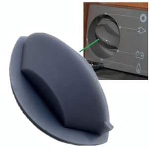 May include: A dark gray, curved handle with a pointed end, likely for a cabinet or drawer. The handle is shown in front of a control panel with a rotary dial and various indicator symbols, including a battery and a gas flame.