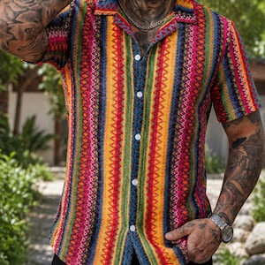 May include: A short-sleeved button-down shirt featuring a vibrant, vertical striped pattern in shades of red, yellow, green, and blue. The shirt has a classic collar, white buttons down the front, and a textured fabric with intricate geometric details.