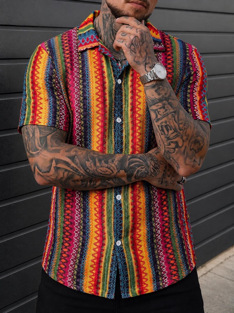 May include: A short-sleeved button-down shirt featuring a vibrant vertical striped pattern in shades of yellow, red, green, blue, and purple. The shirt has a classic collar, a front button placket with white buttons, and a textured fabric finish.