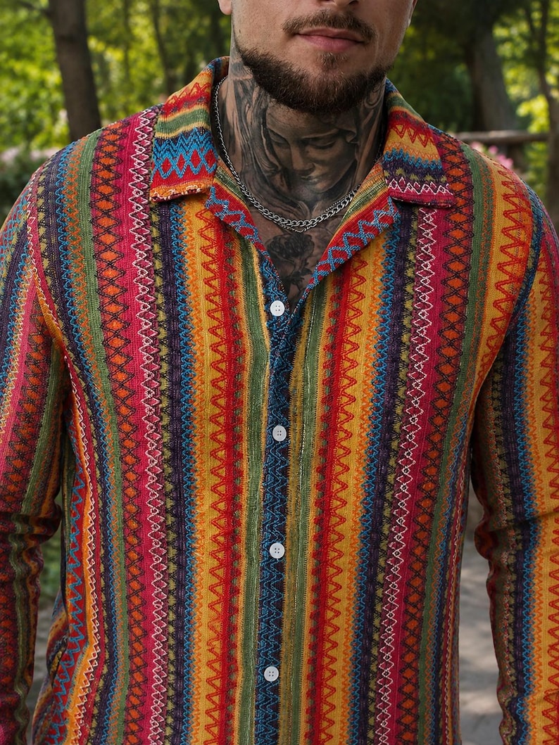 May include: A long-sleeved button-down shirt featuring a vibrant, multi-colored vertical striped pattern. The design incorporates repeating geometric motifs in shades of red, yellow, green, orange, and blue, finished with a classic collar.