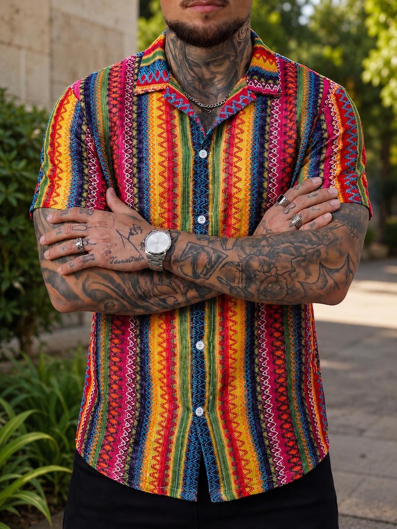 May include: A short-sleeved button-down shirt featuring a vibrant, vertical striped pattern in shades of red, yellow, green, and blue. The shirt has a classic collar and white buttons running down the center front, with a textured, woven appearance.