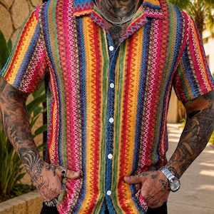 May include: A short-sleeved button-down shirt featuring a vibrant, multi-colored vertical striped pattern in shades of pink, yellow, green, blue, and orange. The shirt has a classic collar, white buttons, and a textured fabric finish throughout.