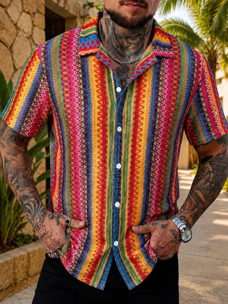 May include: A short-sleeved button-down shirt featuring a vibrant, multi-colored vertical striped pattern in shades of pink, yellow, green, blue, and orange. The shirt has a classic collar, white buttons, and a textured fabric finish throughout.
