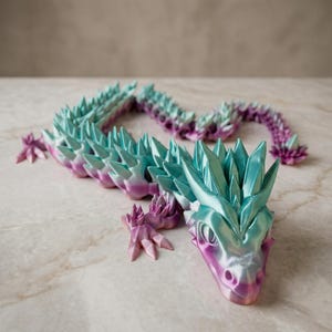 Könnte beinhalten: Eine weiße Keramik-Tasse mit schwarzem Henkel und dem Text "But First, Coffee" in schwarzer, handschriftlicher Schrift. Die Tasse steht auf einer weißen Oberfläche.