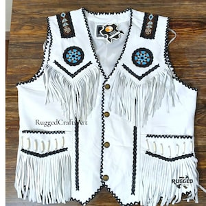 May include: White leather vest with fringe and decorative beading. Features black trim, pockets, and button closures. The text "RuggedCraftsArt" is visible on the front.
