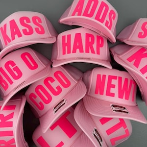 May include: A white ceramic mug with a black handle and the text "But First, Coffee" in a black, handwritten-style font. The mug is on a white surface.