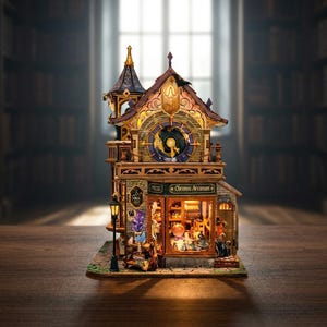 May include: A miniature building model titled Chronos Arcanum featuring a clock face on the upper level, a lit storefront with a display of small items, a black cat figure, a street lamp, and intricate architectural details in brown and gold tones.