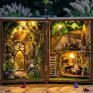 Könnte beinhalten: Ein detailliertes Miniatur-Holzdiorama, das eine Feengarten-Szene darstellt. Das Diorama ist mit warmen Lichtern beleuchtet und zeigt einen Weg, Blumen und einen gemütlichen Raum mit Möbeln und Büchern. Das Diorama ist geöffnet und zeigt die komplizierten Details.