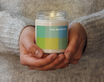 Scented soy candle with "you are loved" message on color block plaid design