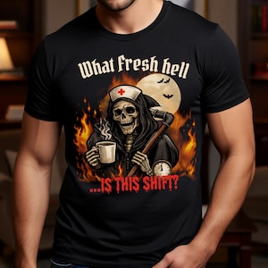 May include: Black t-shirt featuring a grim reaper in a nurse's cap holding a coffee mug and a scythe. The design includes flames, a full moon, bats, and the text "What fresh hell...is this shift?"
