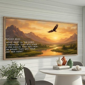 May include: A framed landscape art print featuring a majestic eagle soaring over a river and mountains at sunset. The artwork includes the text "ISAIAH 40:31" and a Bible verse. The print is displayed above a white table with decorative vases.