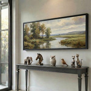 May include: A long, dark gray console table displays decorative animal figurines and a landscape painting. The figurines include an elephant, horse head, owl, bird, and two cats. The painting depicts a river scene with trees.