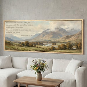 Puede incluir: Pintura de paisaje enmarcada en un marco de madera clara. La obra de arte representa un valle con montañas, un río y árboles. El texto en la parte superior dice: "El Señor te bendiga y te guarde...Números 6:24-26."