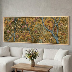 May include: A framed floral art print featuring a stylized botanical design. The artwork showcases a mustard-yellow background with blue tree branches and various flowers in pink, red, and white. The rectangular frame is made of light-colored wood.