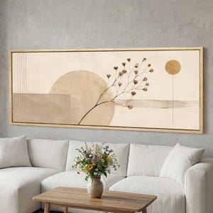 May include: Abstract art print in a rectangular wooden frame. The artwork features a beige background with geometric shapes, a circular design, and a branch with small, brown flower buds. A gold-coloured sun is also depicted.