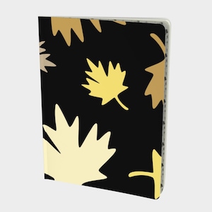 May include: A white ceramic mug with a black handle and the text "But First, Coffee" in a bold, black font. The mug is set against a blurred background, suggesting a cozy setting.