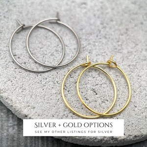 Puede incluir: Dos pares de pendientes de aro finos, un par en tono plateado y otro en tono dorado. Los pendientes presentan un dise&ntilde;o circular sencillo de alambre con un peque&ntilde;o mecanismo de cierre. El texto SILVER + GOLD OPTIONS SEE MY OTHER LISTINGS FOR SILVER es visible.