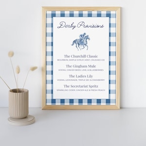 May include: A framed print with a blue and white gingham border. The print features the text "Derby Provisions" above a watercolor illustration of a horse race. Below, a list of cocktail recipes is displayed.