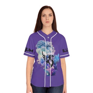May include: Purple baseball jersey with white trim and button-up front. The jersey features a colorful graphic of a face with smoke-like clouds and the word "ILLUM" on the left chest and right sleeve.