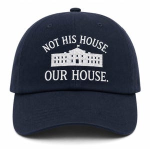 Puede incluir: Una gorra de béisbol azul marino con texto bordado en blanco que dice NOT HIS HOUSE. OUR HOUSE. junto a una ilustración gráfica blanca del edificio de la Casa Blanca situada entre las dos líneas de texto en la parte frontal.