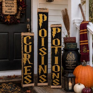 May include: Three tall black wooden signs with gold lettering reading CURES, POISONS, and POTIONS, each featuring lightning bolt accents. The signs are decorated with twine at the top and bottom, displayed alongside a Hogwarts-themed mat, books, a broom, a scarf, a black cauldron, a lantern, and pumpkins.