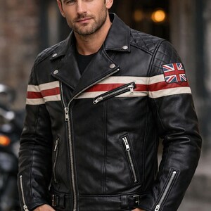 Puede incluir: Chaqueta de cuero negra de estilo motero con diseño acolchado en los hombros, una franja blanca y roja en el pecho y un parche de la Union Jack en la parte superior del brazo. La chaqueta tiene múltiples bolsillos con cremallera y cierre de cremallera plateado.