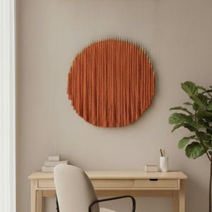 Puede incluir: Un despacho en casa con un escritorio de madera, una silla de oficina beige y una alfombra redonda de yute. Un adorno de pared circular naranja es el punto focal. Una planta en maceta blanca está a la derecha. El escritorio mide 120 cm de ancho.