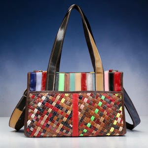 May include: A colorful leather tote bag with a woven front panel and a striped top section. The bag features a variety of colors, including red, brown, blue, and green. It has two handles and a detachable shoulder strap.