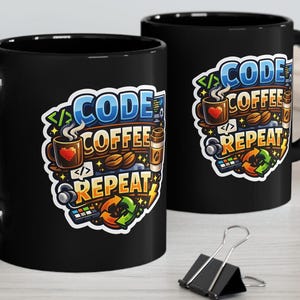 Pode incluir: Duas canecas de café pretas com as palavras "CODE COFFEE REPEAT" em um design colorido. O design inclui grãos de café, uma xícara de café e símbolos de codificação. As canecas estão em uma superfície clara.