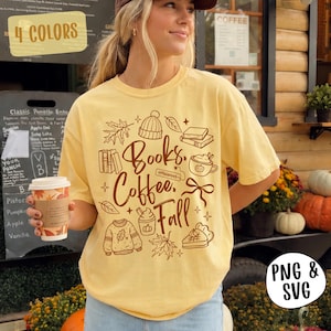 May include: A pale yellow short-sleeve t-shirt featuring a brown graphic print with the text Books, Coffee, Fall. The design includes illustrations of a beanie, books, a coffee mug, a bow, a sweater, a maple leaf, and a slice of pie.