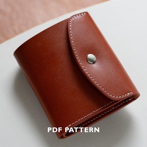 Può includere: Un portafoglio in pelle marrone con chiusura a patta e bottone automatico argentato. Il portafoglio rettangolare presenta cuciture bianche sui bordi. Il testo "PDF PATTERN" è visibile in basso.