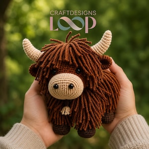 May include: A crocheted Highland cow plushie with brown shaggy fur, tan horns, and a tan muzzle. The handmade toy has black eyes and a small bell. The image includes the text "CRAFTDESIGNS LOOP" in pink and green.