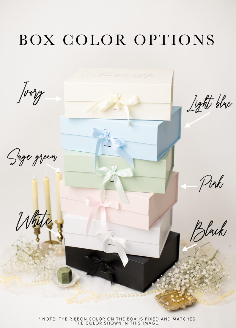 May include: A stack of six rectangular gift boxes with ribbon closures, labelled BOX COLOR OPTIONS. Colours include ivory, light blue, sage green, pink, white, and black. Each box features a matching ribbon tie. Text notes that ribbon colour is fixed.
