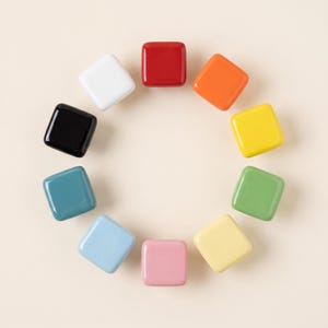 Puede incluir: Una colección de diez botones cuadrados de superficie lisa dispuestos en un patrón circular. Los botones tienen un acabado brillante y vienen en una variedad de colores sólidos que incluyen rojo, naranja, amarillo, verde, amarillo claro, rosa, azul claro, azul verdoso, negro y blanco.