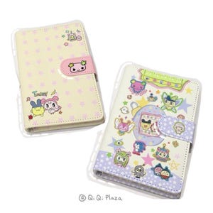 May include: Two pastel-coloured phone cases featuring cartoon character designs. One case is light yellow with pink stars and a pink clasp. The other is white with a purple star pattern and a light purple clasp. Both cases have cartoon character illustrations.