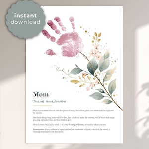 Könnte beinhalten: Ein digitaler Druck mit einem rosa Handabdruck und floralem Aquarelldesign. Das Wort "Mom" wird in einer stilvollen Schriftart zusammen mit einer Definition und Synonymen angezeigt. Die Worte "sofortiger Download" befinden sich in einem Kreis oben links.