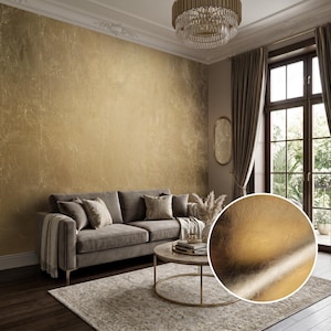 May include: A metallic gold wallpaper featuring a textured, brushed finish that creates a subtle sheen. The surface displays a mottled, organic pattern with varying shades of light and dark gold, providing a reflective quality to the wall covering.