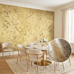 May include: A wall covering featuring a metallic gold leaf texture with an irregular, mottled pattern. The surface displays a reflective, distressed finish with varying shades of light and dark gold, creating a layered, foil-like appearance.