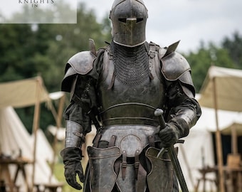 May include: A full suit of dark metal armor, including a helmet, chest plate, and leg guards. The knight is holding a long sword. The image includes the text "Knights In".