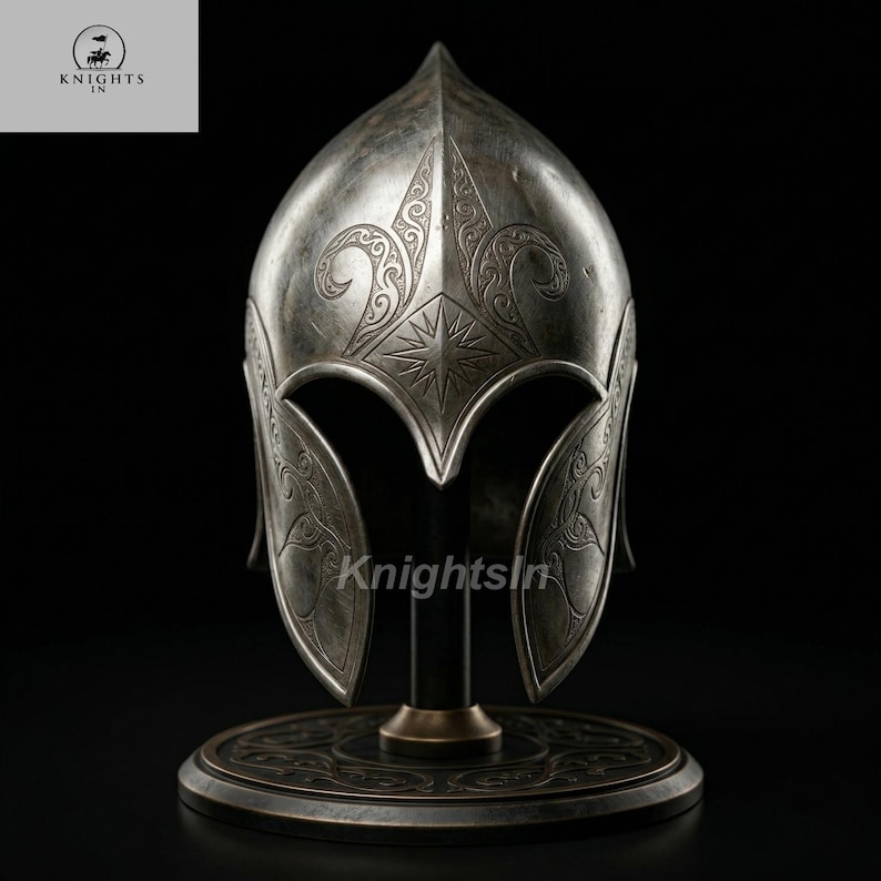 May include: A silver-colored helmet with intricate engraved designs, including a starburst and floral patterns. The helmet is displayed on a black stand with a circular base. The text "Knights In" is visible in the upper left corner.
