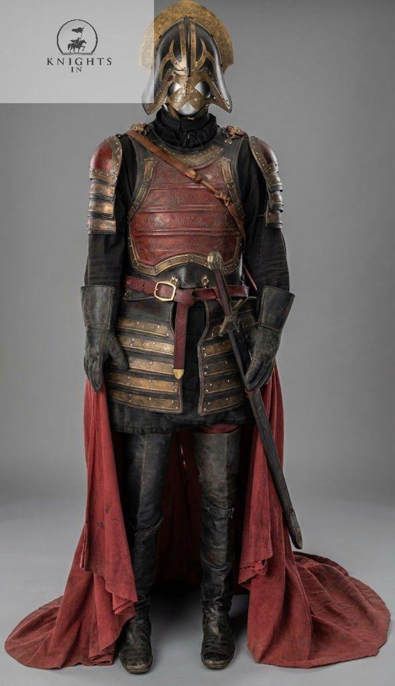 May include: A full suit of medieval armor, featuring a helmet, chest plate, and leg protection. The armor is primarily black and red with gold accents. A sword is sheathed at the waist, and a red cape drapes from the waist down. The image includes the text "Knights In".